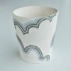 Handmade small white porcelain vessel featuring low relief clouds and multi-coloured stripes. Decorative item.